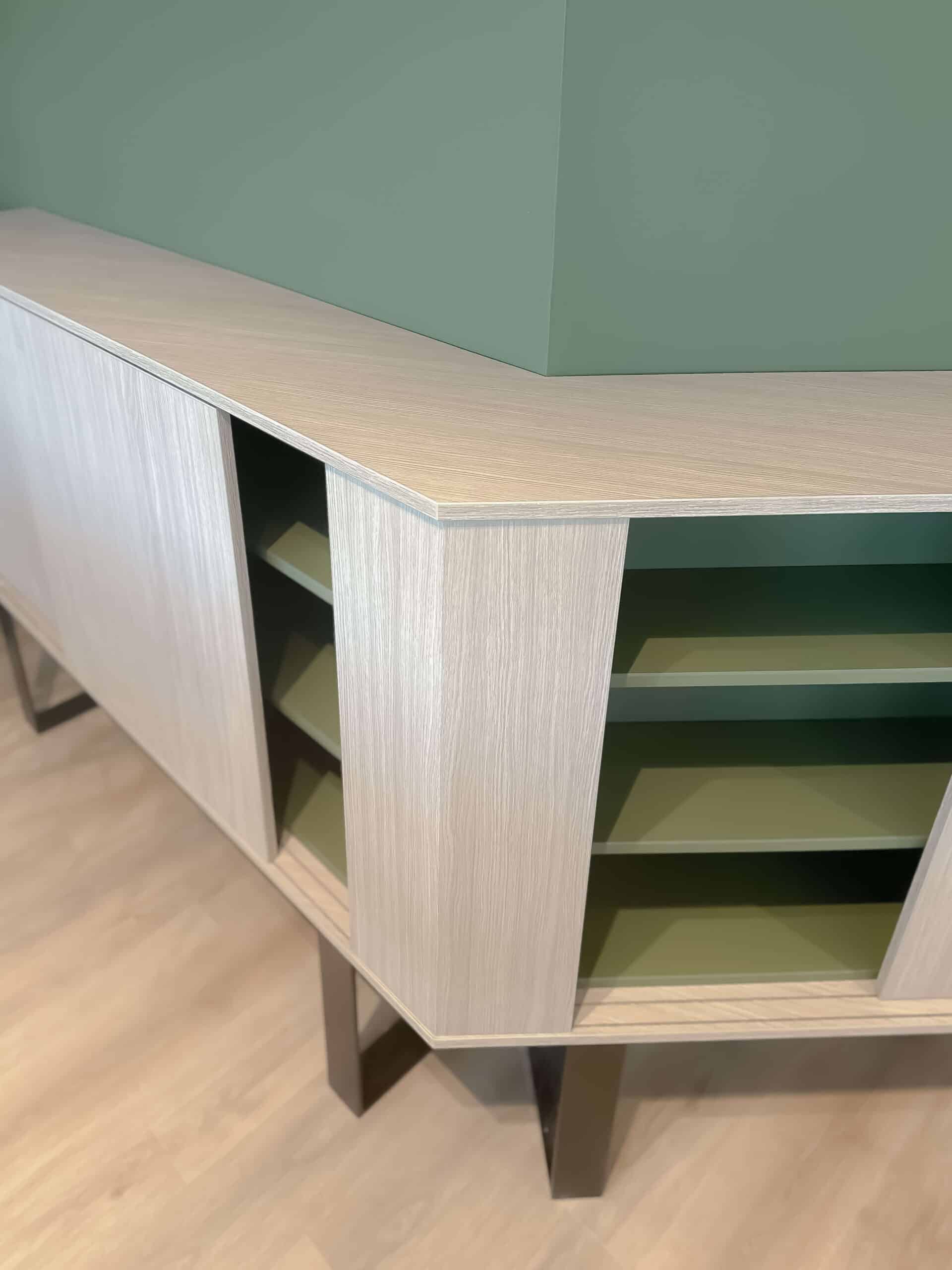 Buffet d'angle en bois clair, étagères vert olive, design moderne et géométrique.