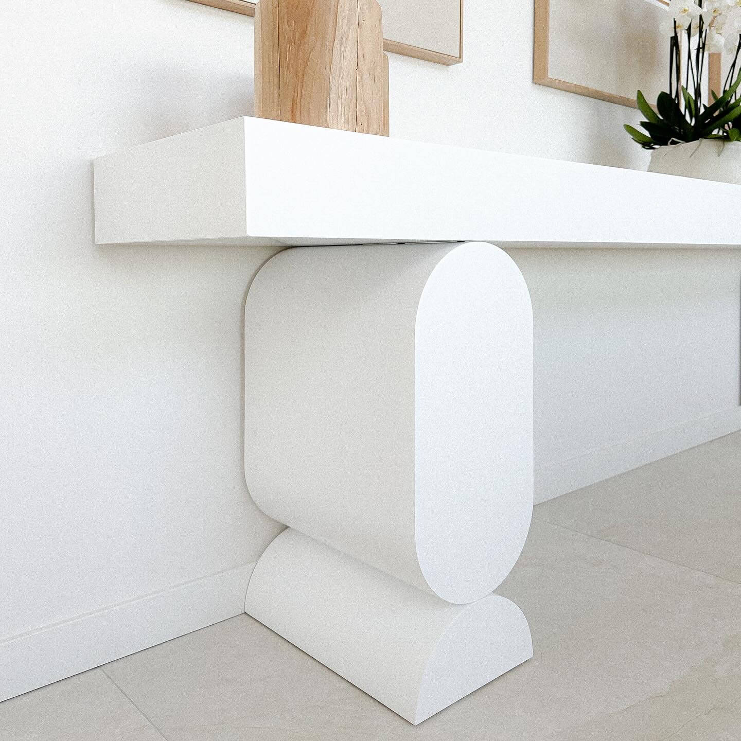 Console blanche minimaliste aux formes géométriques épurées.