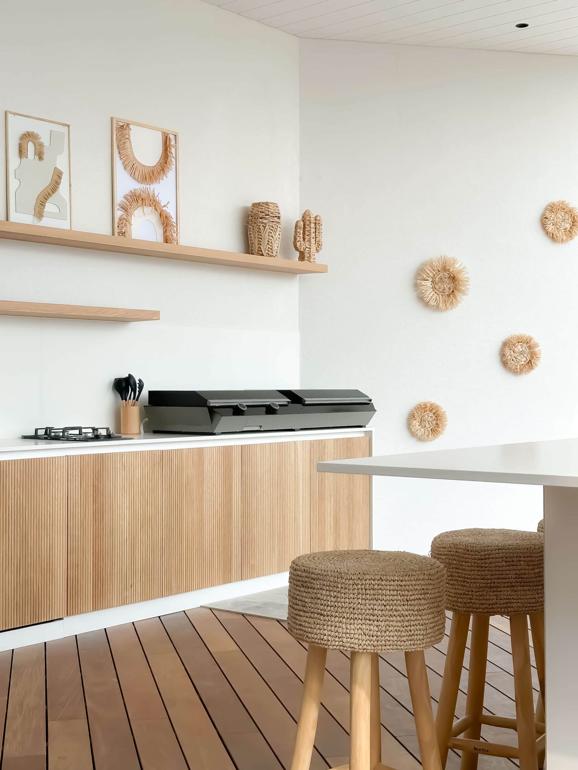 Cuisine extérieure bohème, meubles en bois strié et tabourets tressés.