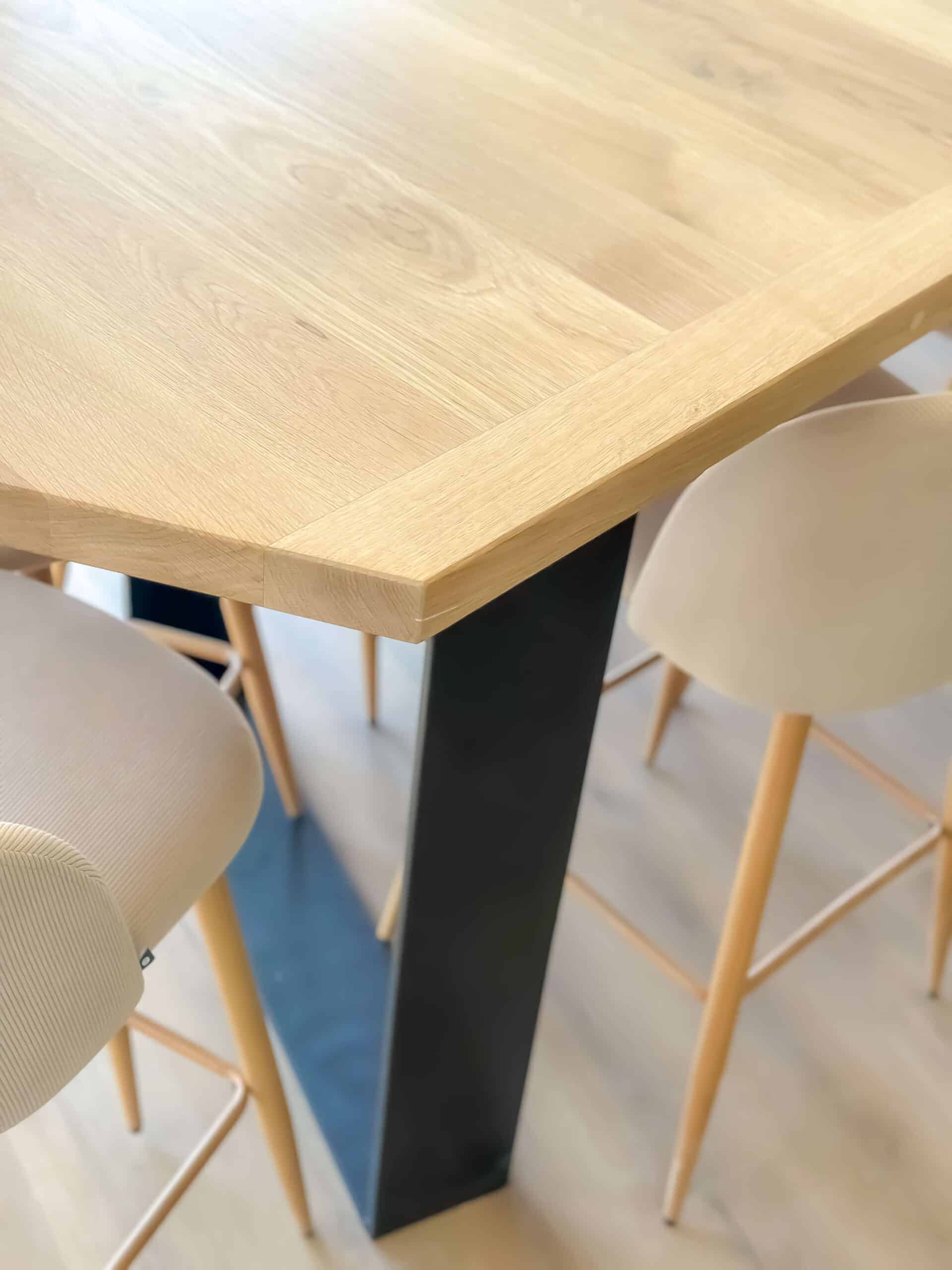 Table en chêne clair, pied métal noir industriel et tabourets hauts scandinaves beiges.